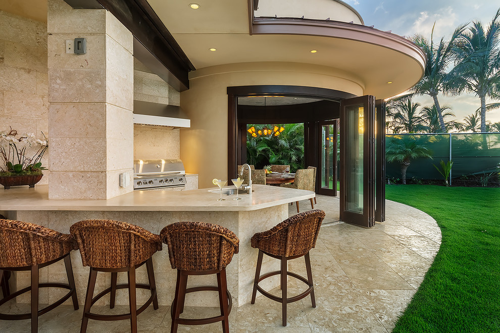 Foto di un grande patio o portico tropicale dietro casa con un tetto a sbalzo e piastrelle