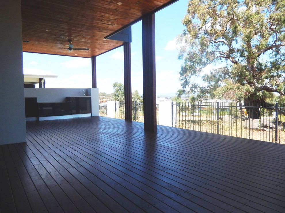 This is an example of a large modern back patio in Canberra - Queanbeyan with an outdoor kitchen, decking and a roof extension.