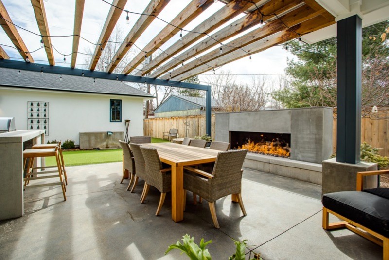 Inspiration for a large country back patio in Denver with a fireplace and a pergola.