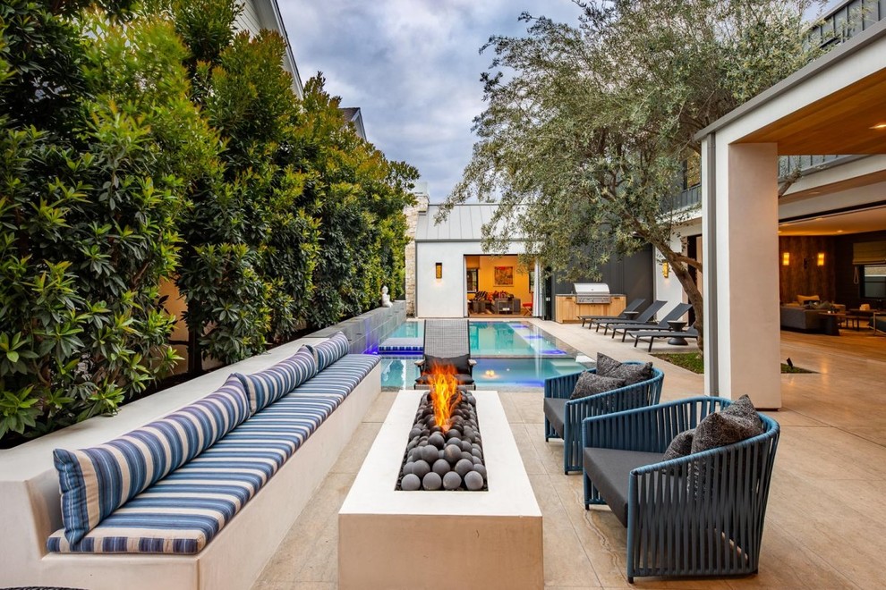 Photo of a contemporary patio in Orange County with a fire feature and no cover.