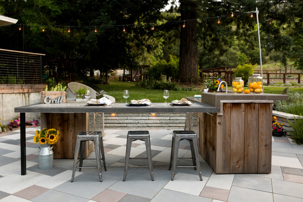 Diseño de patio de estilo de casa de campo sin cubierta en patio trasero con adoquines de piedra natural