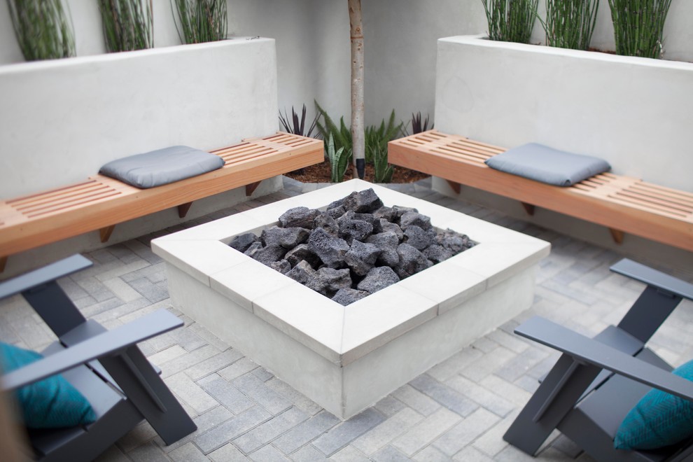 Inspiration for a mid-sized modern backyard brick patio remodel in Orange County with a fire pit and no cover