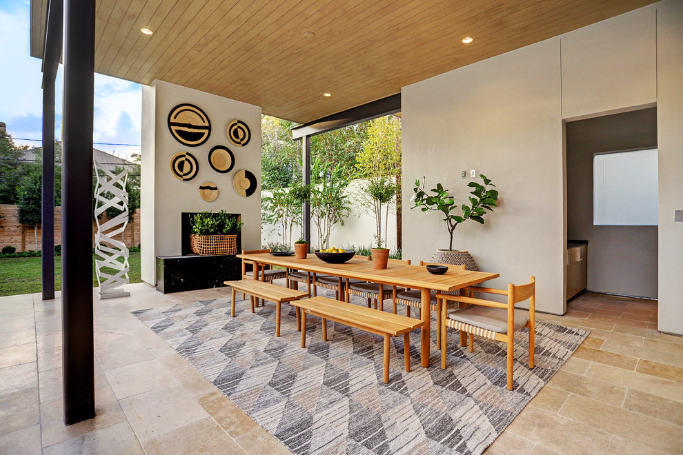 Inspiration for a contemporary backyard tile patio remodel in Houston with a fireplace and a roof extension