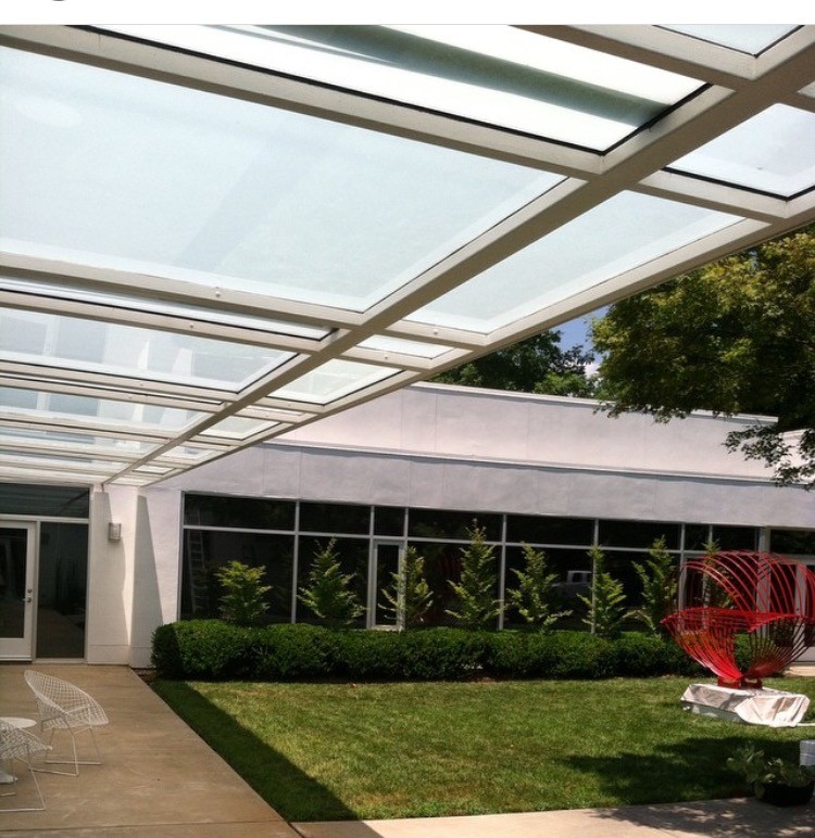 Immagine di un grande patio o portico moderno in cortile con un parasole e lastre di cemento