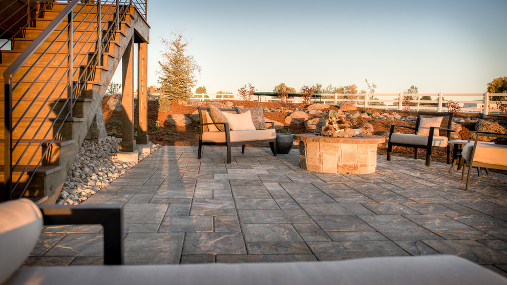 Design ideas for a large classic back patio in Denver with a fire feature and natural stone paving.