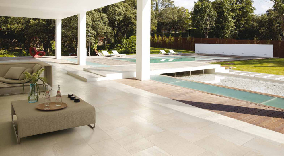Inspiration for a huge modern backyard tile patio remodel in Miami with a roof extension