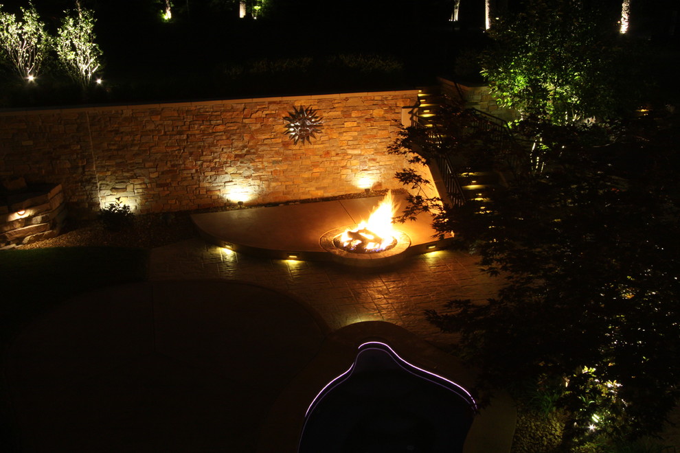 Inspiration for a huge contemporary side yard stone patio remodel in Grand Rapids with a fire pit and a roof extension