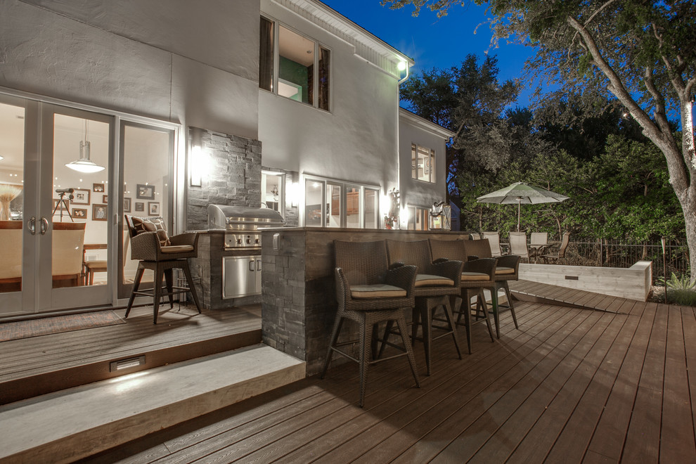 Cette image montre une terrasse en bois arrière minimaliste avec une cuisine d'été.