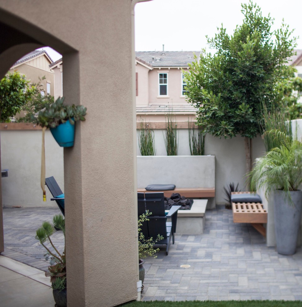 Diseño de patio moderno de tamaño medio sin cubierta en patio trasero con adoquines de ladrillo
