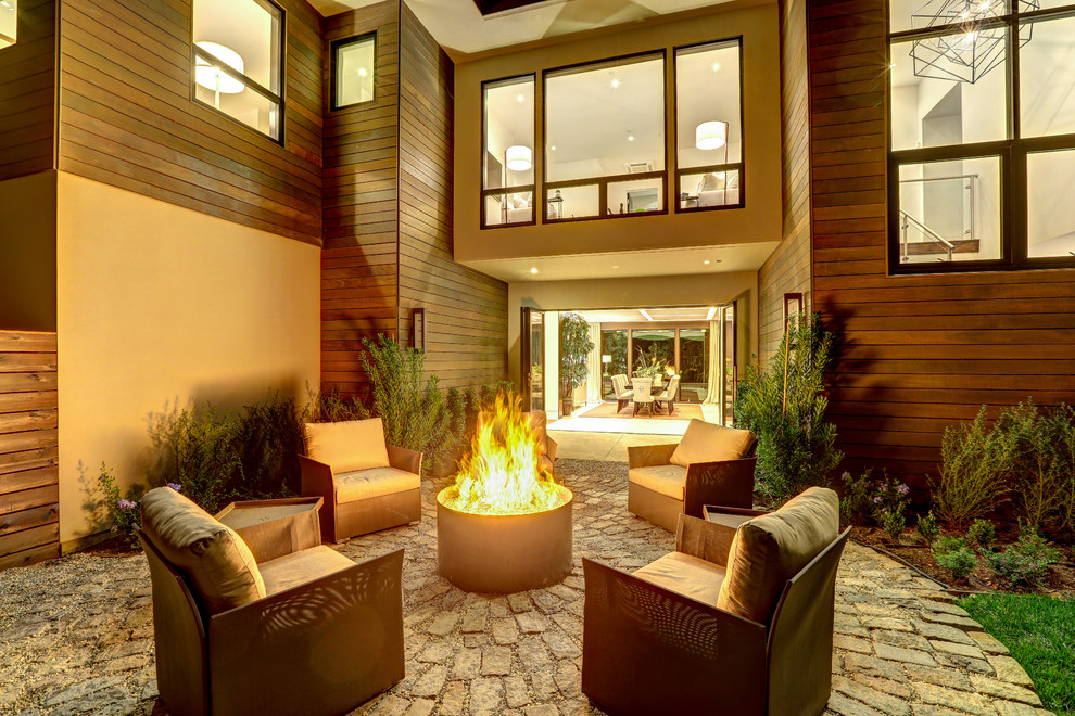 Inspiration pour une grande terrasse latérale design avec un foyer extérieur, des pavés en béton et aucune couverture.