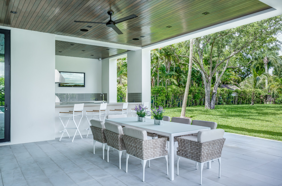 Photo of a contemporary patio in Miami with a roof extension.