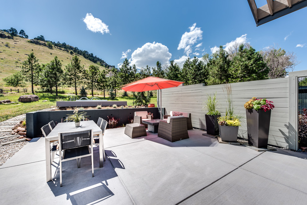 Photo of a medium sized modern back patio in Denver with concrete slabs and no cover.