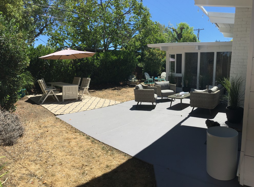 Inspiration for a medium sized contemporary back patio in Orange County with concrete slabs and a roof extension.