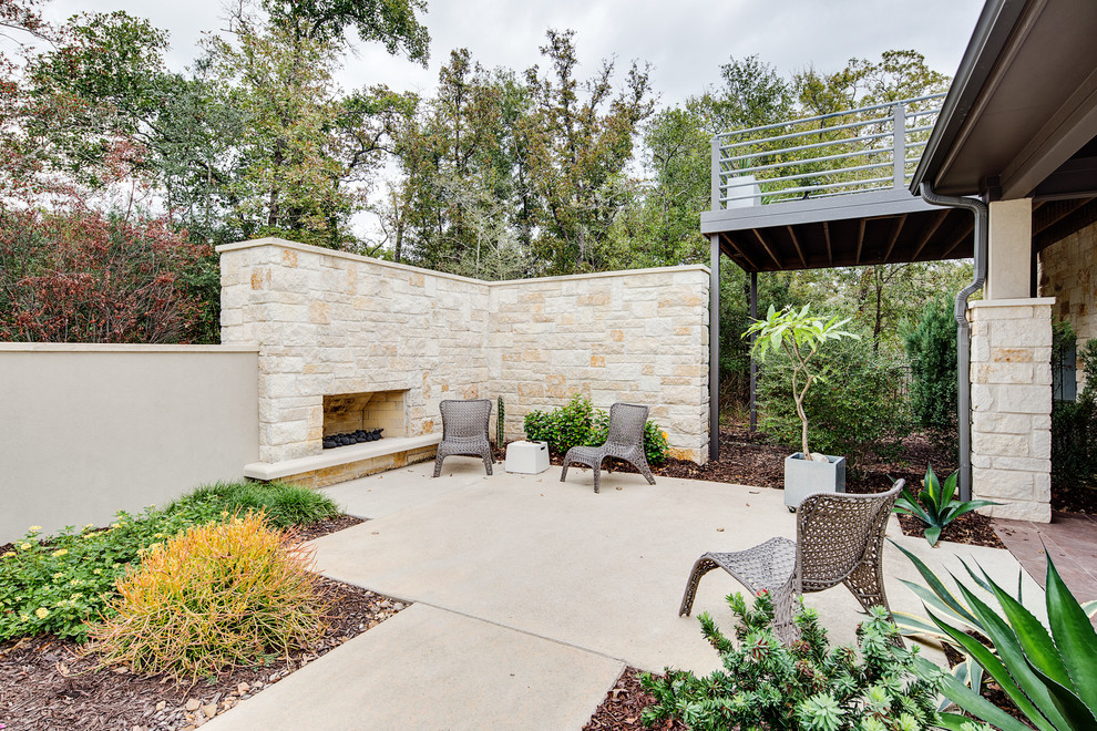 Foto de patio moderno de tamaño medio sin cubierta en patio trasero con brasero y losas de hormigón