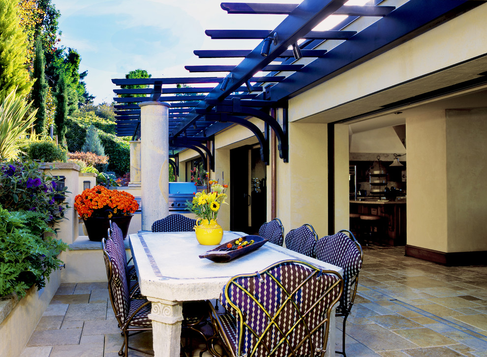 Inspiration pour une grande terrasse arrière méditerranéenne avec une cuisine d'été, du carrelage et une pergola.