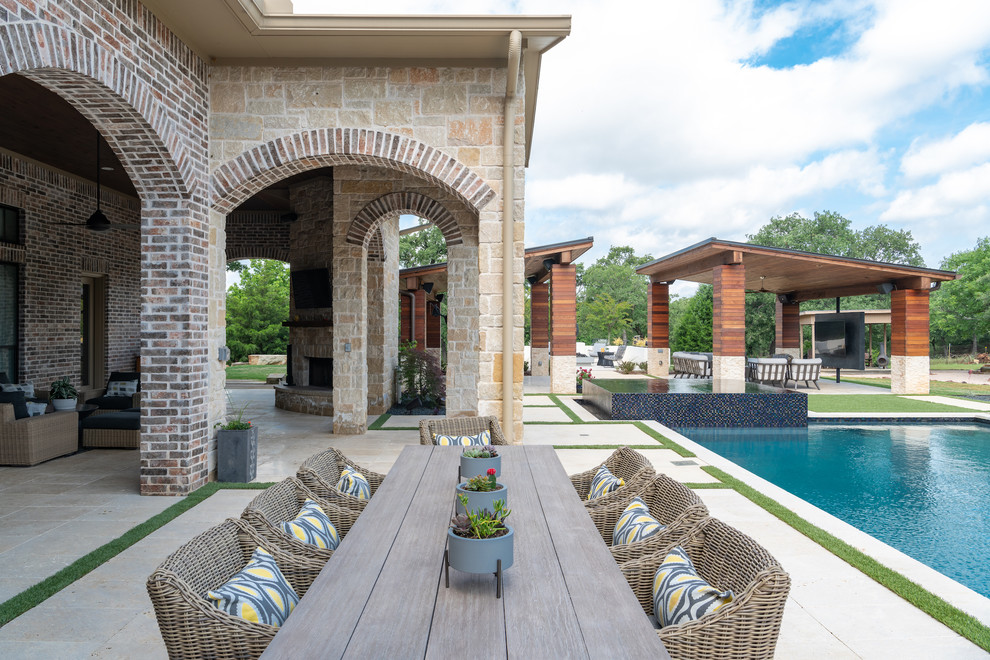 Example of a huge classic backyard patio design in Dallas with a fire pit