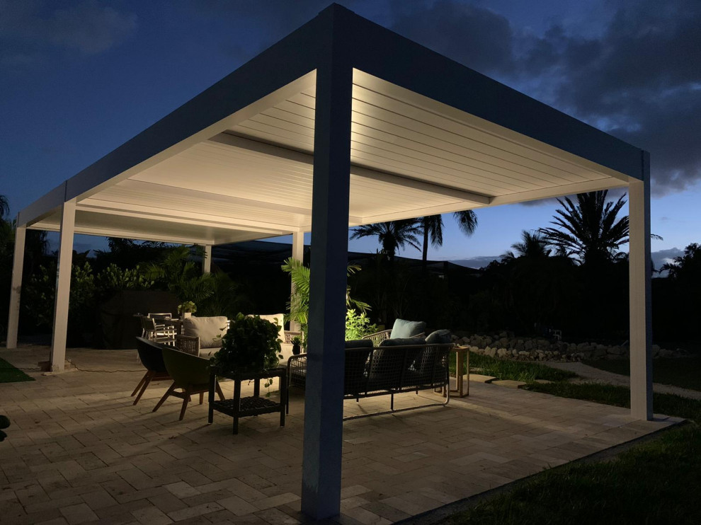 Inspiration pour une terrasse latérale minimaliste de taille moyenne avec des pavés en pierre naturelle et une pergola.