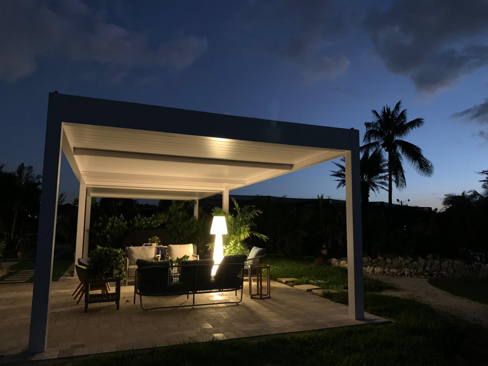 Patio - mid-sized modern side yard stone patio idea in Miami with a pergola