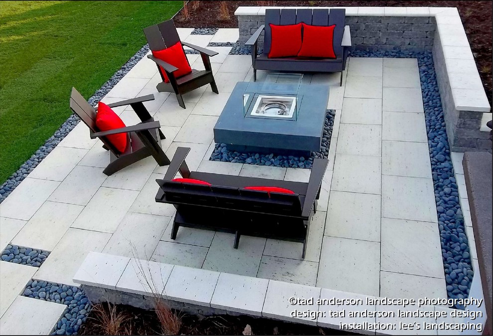 Diseño de patio moderno en patio trasero con brasero y adoquines de piedra natural