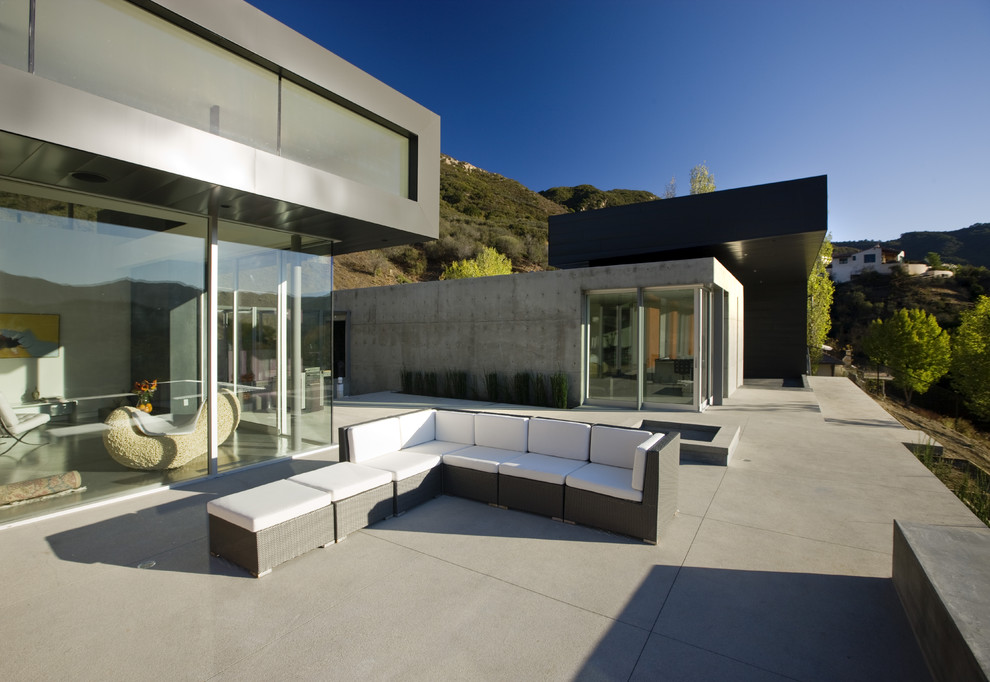 На фото: двор в стиле модернизм с покрытием из бетонных плит без защиты от солнца с
