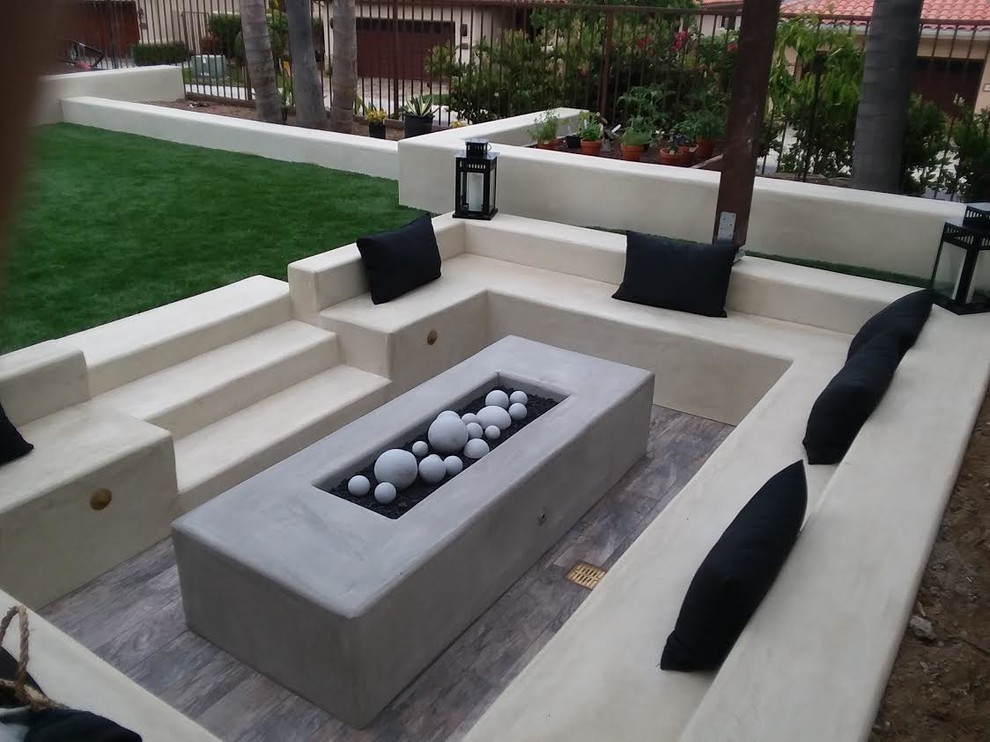 Modelo de patio moderno grande en patio trasero con brasero, adoquines de hormigón y pérgola