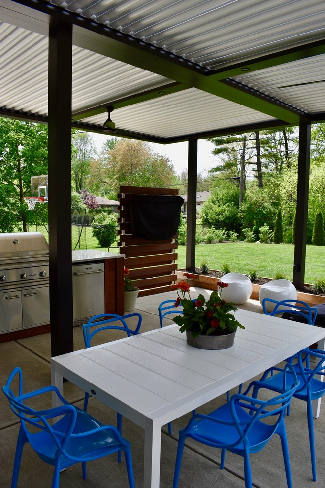 Aménagement d'une terrasse arrière contemporaine avec une cuisine d'été et une pergola.