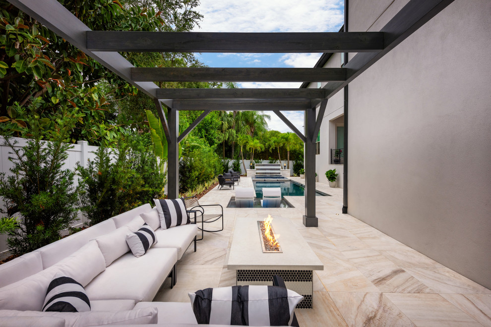 Patio - mid-sized contemporary backyard stone patio idea in Tampa with a fire pit and a pergola