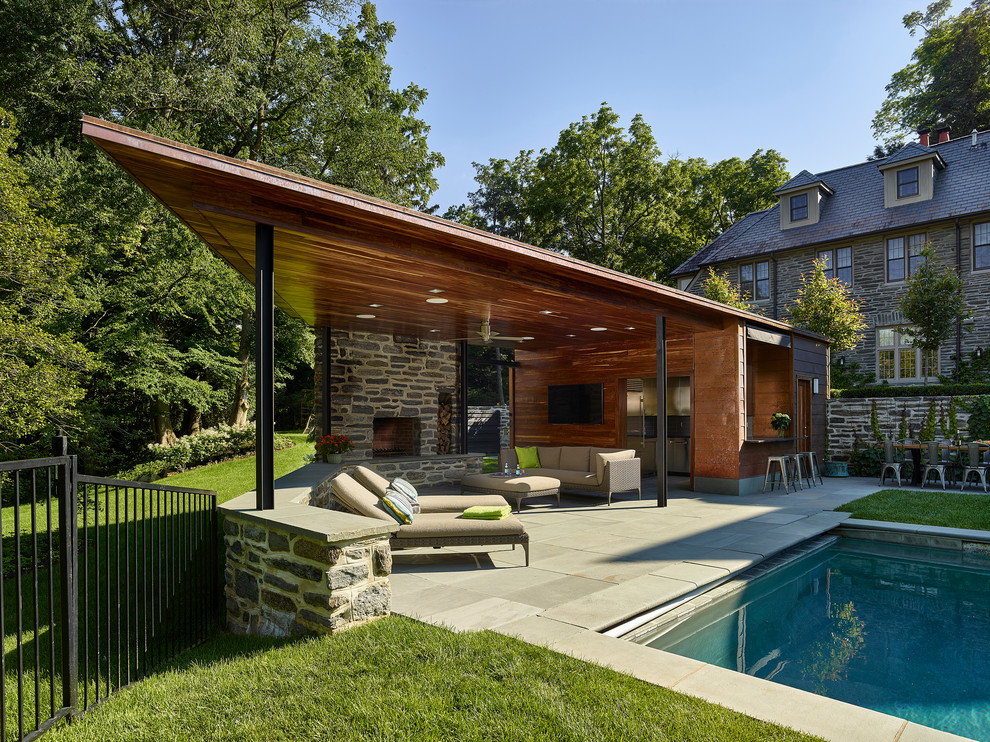 Immagine di un patio o portico design dietro casa con un focolare, pavimentazioni in pietra naturale e un gazebo o capanno