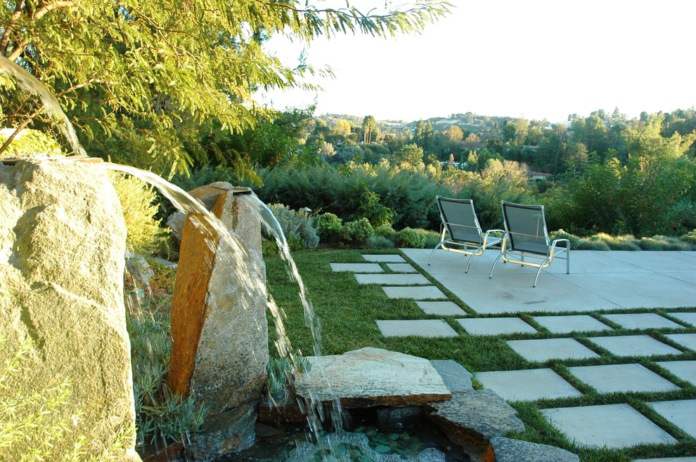 Foto de patio contemporáneo extra grande sin cubierta en patio trasero con fuente y adoquines de hormigón
