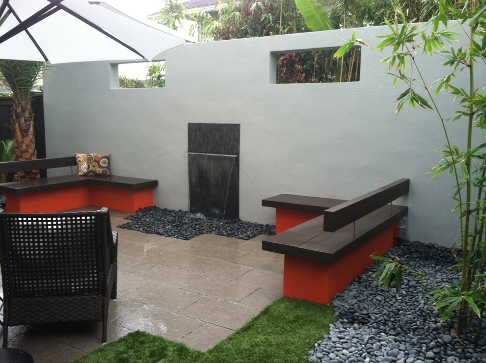 Esempio di un piccolo patio o portico minimalista dietro casa con fontane e pavimentazioni in pietra naturale
