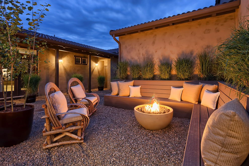 Patio - large southwestern courtyard gravel patio idea in Denver with a fire pit