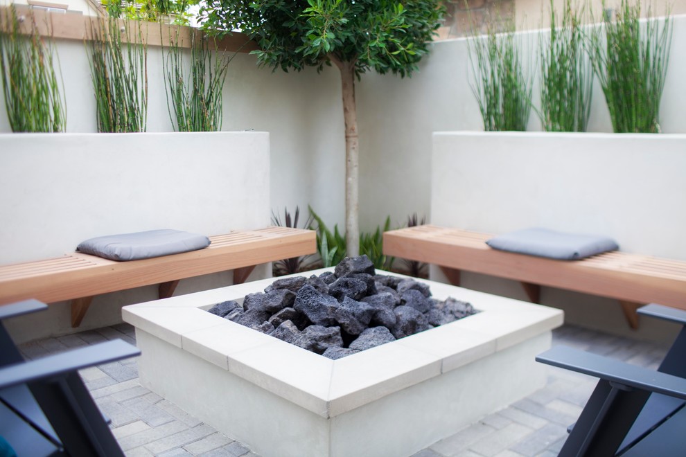 Inspiration for a medium sized modern back patio in Orange County with a fire feature, brick paving and no cover.