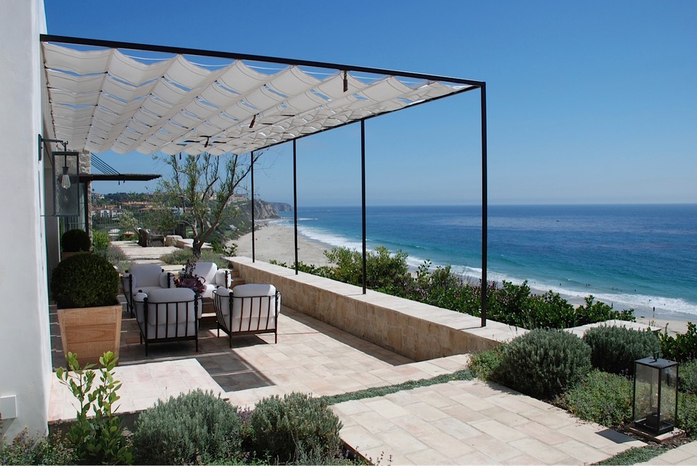 Cette photo montre une très grande terrasse arrière méditerranéenne avec un foyer extérieur, du gravier et une pergola.