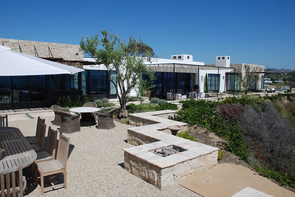 Foto de patio mediterráneo extra grande en patio trasero con gravilla, brasero y pérgola