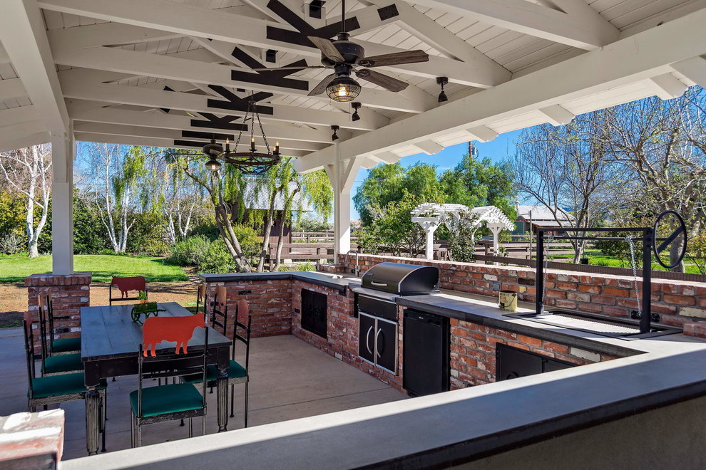 Inspiration pour une très grande terrasse arrière rustique avec une cuisine d'été, une dalle de béton et une extension de toiture.