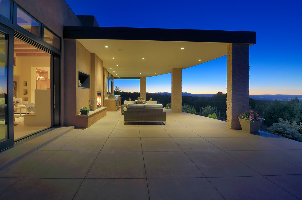 Photo of a large contemporary back patio in Other with a fire feature, tiled flooring and a roof extension.