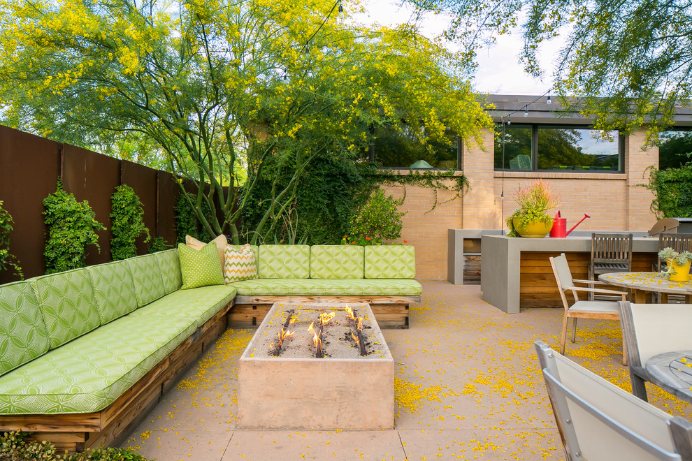 Пример оригинального дизайна: двор на заднем дворе в стиле ретро с местом для костра и покрытием из бетонных плит без защиты от солнца