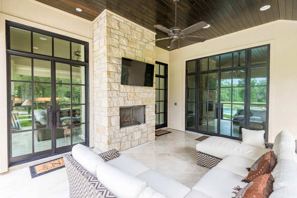 Example of a large transitional side yard tile patio design in Houston with a fireplace and a roof extension
