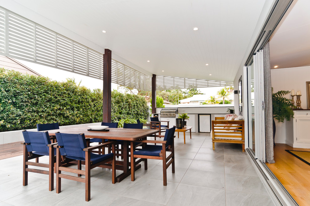 Пример оригинального дизайна: огромный двор на боковом дворе в современном стиле с летней кухней, покрытием из плитки и навесом