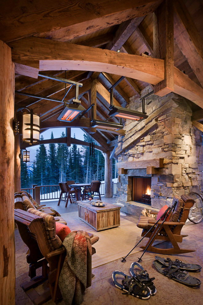 Example of a mountain style patio design in Other with a fire pit and a roof extension