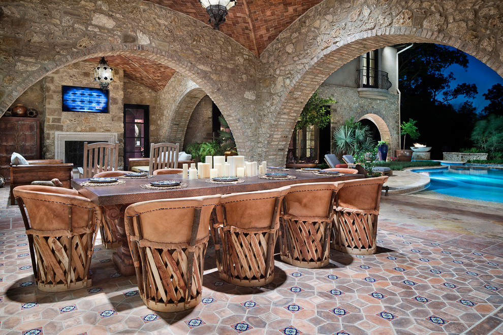 Huge tuscan backyard tile patio photo in Houston with a fireplace and a roof extension