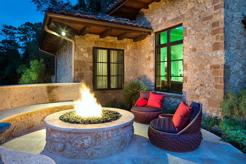 Inspiration for a mid-sized mediterranean backyard tile patio remodel in Houston with a fire pit and no cover
