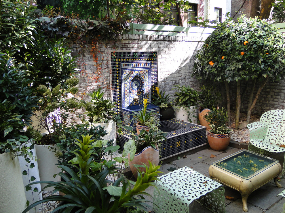 Foto de patio mediterráneo pequeño sin cubierta en patio trasero con adoquines de piedra natural