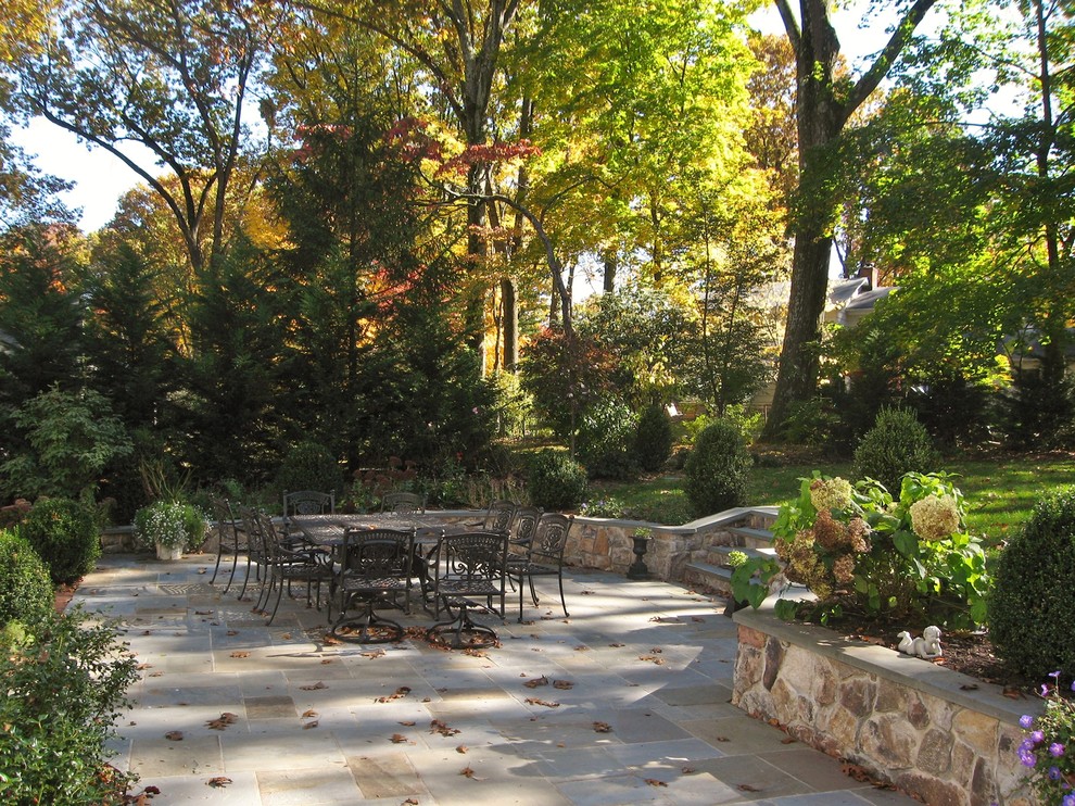 Large classic back patio in New York with natural stone paving and no cover.