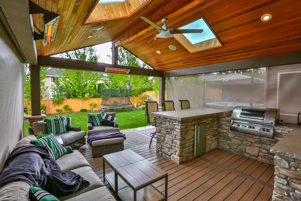 Large classic back patio in Seattle with an outdoor kitchen and a roof extension.