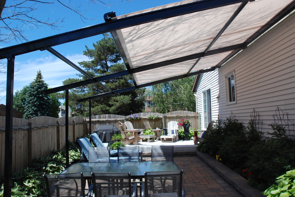 Inspiration for a large classic back patio in Ottawa with an awning.