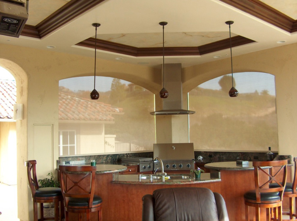 Example of a large classic backyard stone patio kitchen design in San Diego with a roof extension