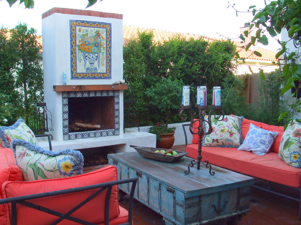 Cette photo montre une terrasse méditerranéenne de taille moyenne avec une cheminée, une cour, des pavés en brique et aucune couverture.
