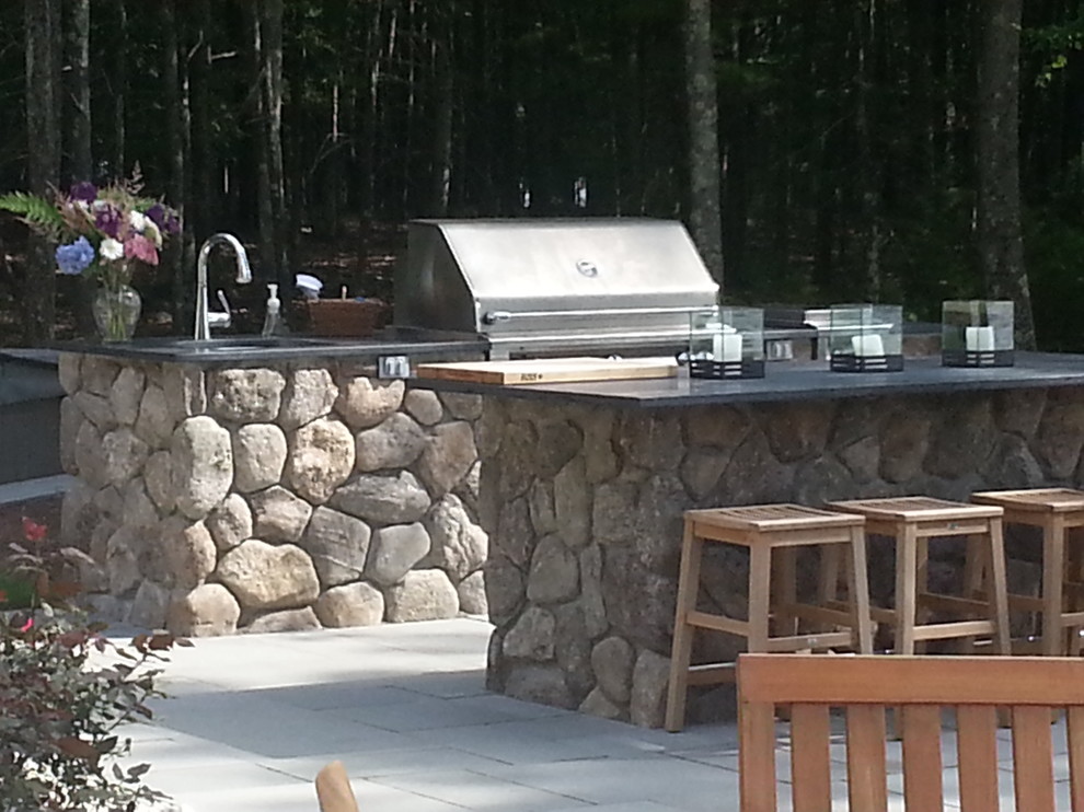 Inspiration for a large timeless backyard stone patio kitchen remodel in Boston with no cover