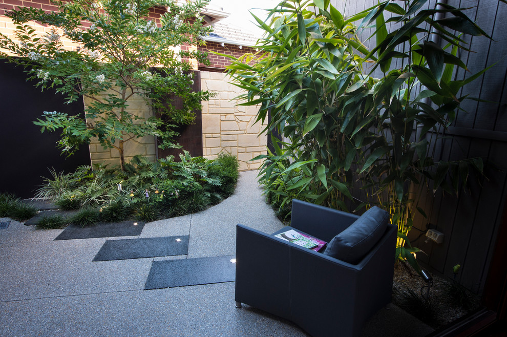 Aménagement d'une petite terrasse contemporaine avec un point d'eau, une cour et des pavés en pierre naturelle.